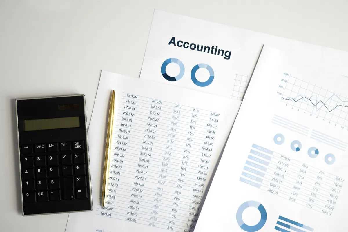 Accounting documents, charts, and calculator used in a financial review