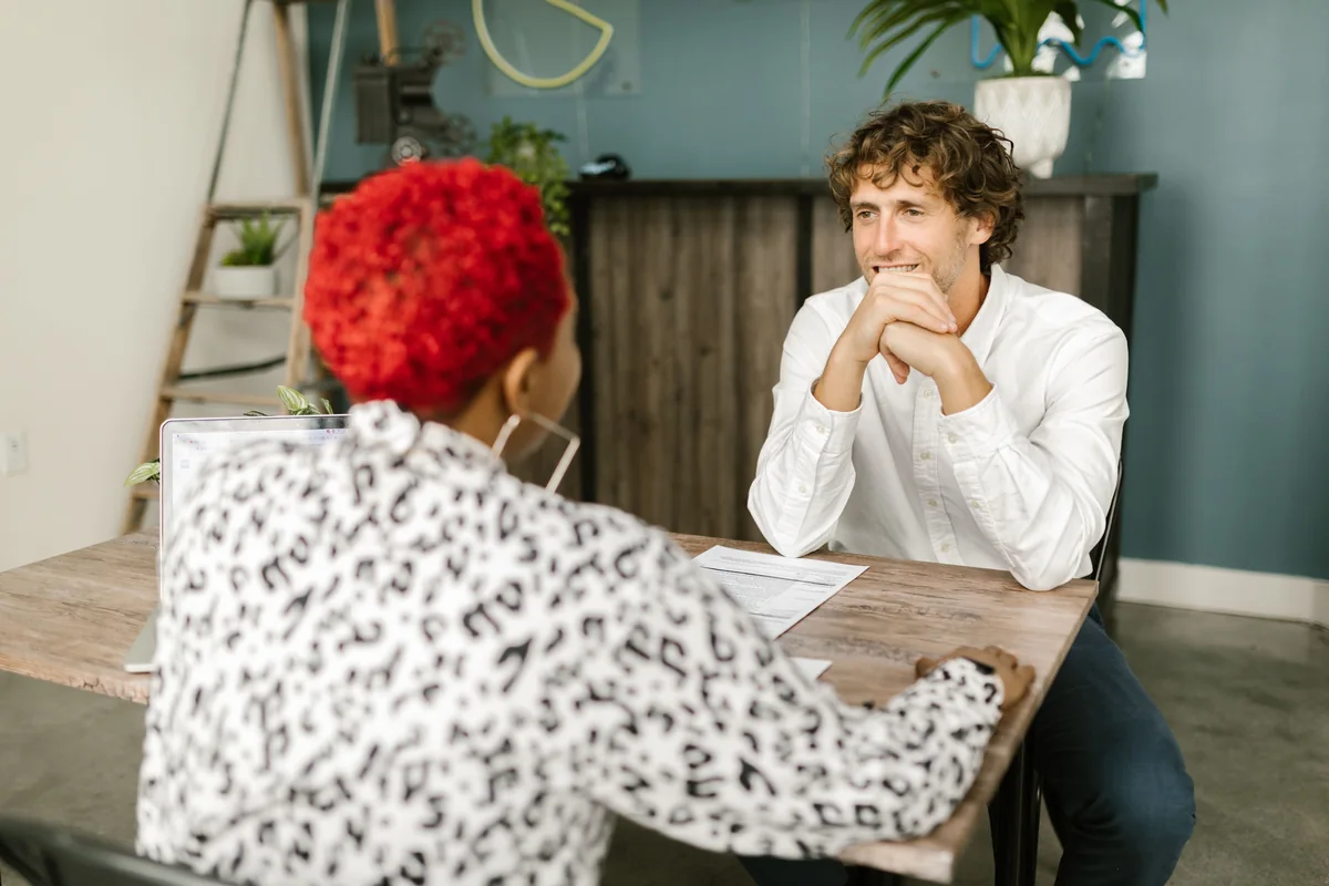 Two adults having a calm conversation across an office desk