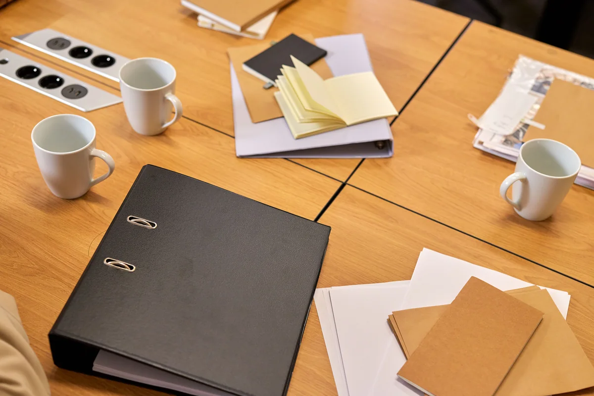 Office desk with binders, papers, and stationery arranged for preparation