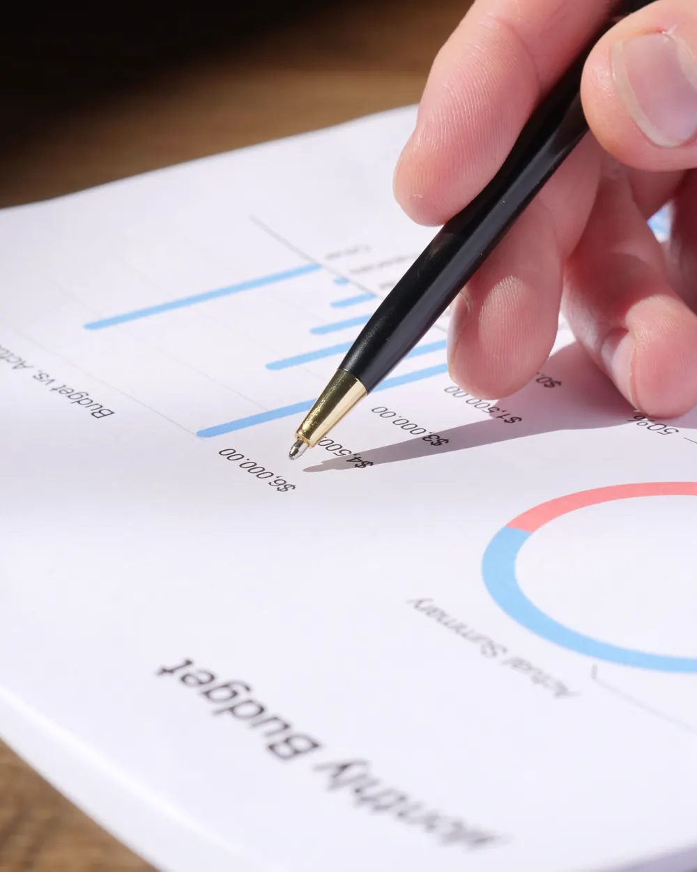 Hand reviewing a household budget and financial charts